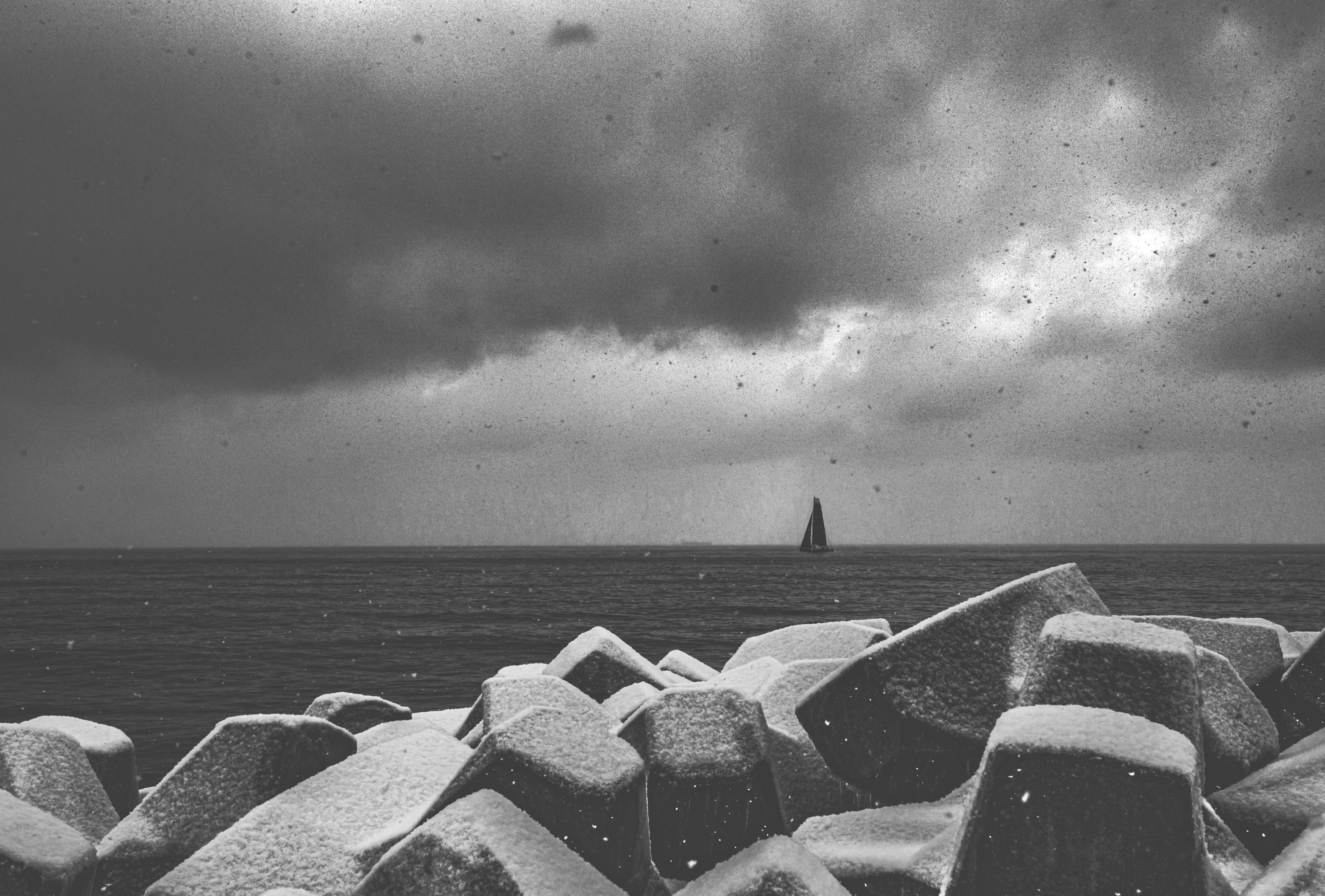 grayscale photo of rocks on beach